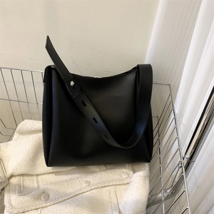 Detail of black tote bag adjustable strap with silver metal studs in a metal basket