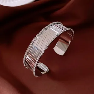 Bracciale rigido aperto argento 18K con strisce geometriche e doppia fila di cristalli