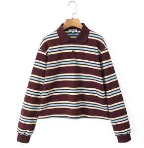 Détail du col polo à rayures bordeaux et des boutons du col sur la chemise en tricot