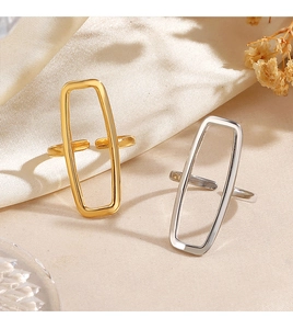 Detail of 18K gold and silver plated rectangular open rings on cream satin fabric