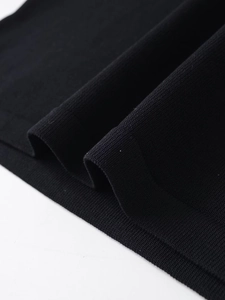 Close-up of the black knit fabric texture and high-quality hem stitching on the T-shirt
