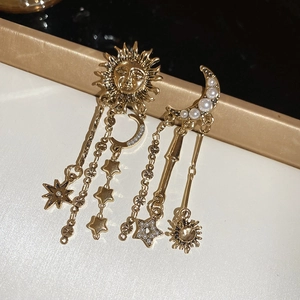 Detailed close-up of vintage gold earrings with sun, moon, star motifs and pearls