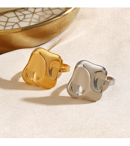 Macro detail of irregular wavy polygon rings in gold and silver on silk background