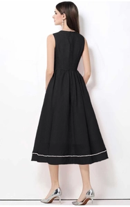 Dettaglio dell'elegante abito midi nero senza maniche con tessuto a trama e perle