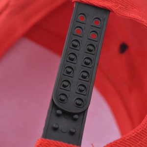 Close-up of the red snapback hat's adjustable black plastic strap and fine stitching
