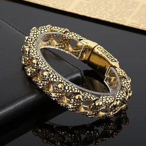 Golden punk skull bracelet in 316L stainless steel on black leather background