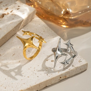 Chic 18K gold and silver starburst open rings on a natural stone surface