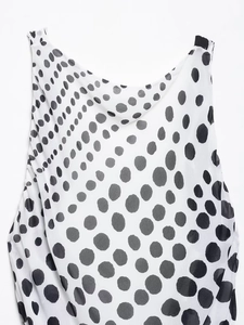 Close-up of black and white polka dot print on flowing sleeveless dress fabric