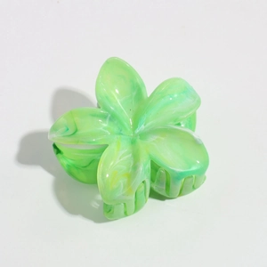 Detail view of a green marbled resin flower hair claw clip with a glossy finish