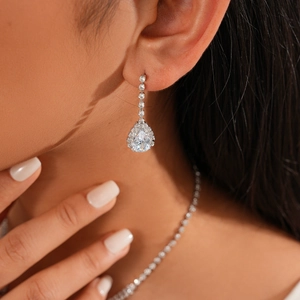 Detailed view of teardrop diamond earrings on model showing elegant bridal style