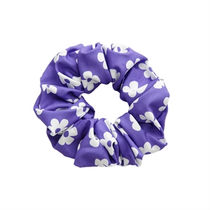 Elastic purple satin scrunchie with white floral pattern on a clean white background