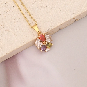 Detailed shot of gold necklace with multi-colored teardrop stones on stone background
