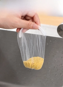 Fine mesh kitchen sink strainer bag showing high efficiency filtering yellow rice grains