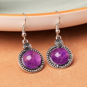 Vue détaillée macro de boucles d'oreilles vintage en argent avec résine violette
