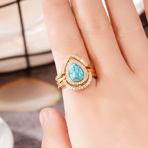 Detail of bohemian gold ring set with teardrop turquoise stone and pave crystals