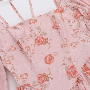 Détail d'une robe fleurie rose avec doubles fines bretelles et buste plissé élégant