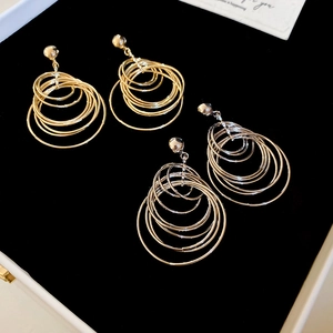 Detail of layered gold and silver hoop earrings on black velvet jewelry box tray