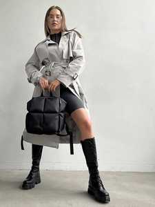 Sac à dos matelassé noir tendance porté avec un trench gris pour un style urbain chic