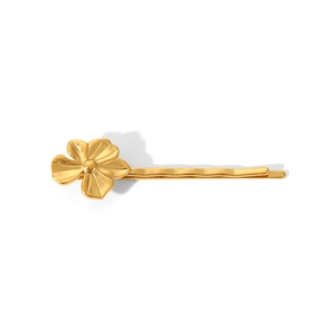 Dettaglio di una clip per capelli a fiore d'oro lucido con design metallico minimalista