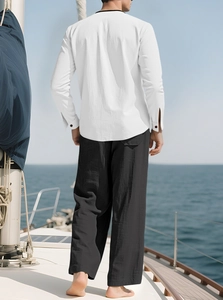 Men's white linen shirt and black pants beach set worn on a sailing boat with sea view