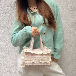 Détail d'un cabas en toile florale avec bordures en dentelle et écusson logo de marque