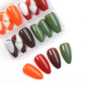 Almond-shaped press-on nail set featuring orange, green, and gold geometric designs