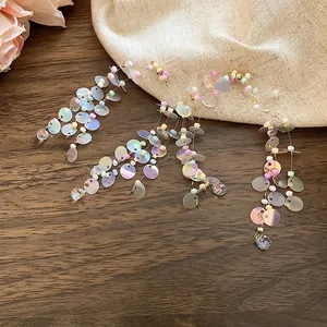 Rainbow sequin tassel earrings with macaron beads and drop crystal on wood background