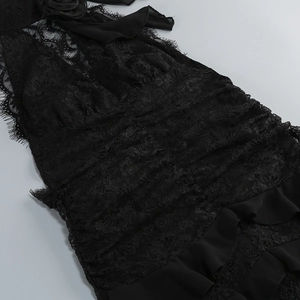 Close-up of black floral lace fabric and tiered ruffle details on a slim evening gown