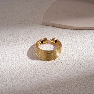 Detail of a gold multilayer wide wire-wrap ring with a textured metallic finish