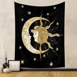 Detail of artistic black tapestry with sun and moon pattern hanging on a gray room wall