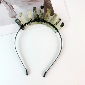 Macro detail of handmade black wire tiara featuring green textured crystal rectangles