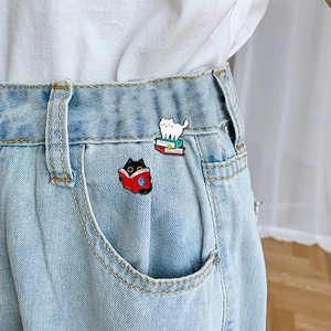 Cute black and white cat enamel pins set attached to a denim jeans pocket for decoration
