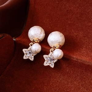 Detail of 18K gold plated pearl star earrings with textured beads and sparkling rhinestones