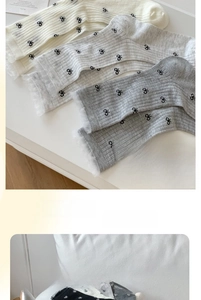 Detail of sheer ribbed crew socks with black bow patterns and elegant lace ruffle cuffs