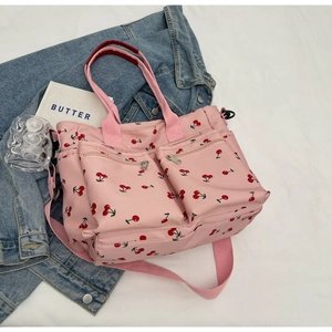 Detail of pink canvas tote bag with cherry prints and multiple functional zipper pockets