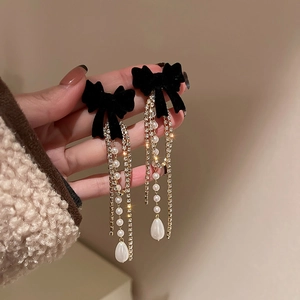 Details von Vintage-Ohrringen mit schwarzer Samtschleife, Goldketten, Perlen und Kristallen