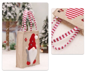 Detail of Christmas burlap gift bag with 3D gnome applique and red striped handles