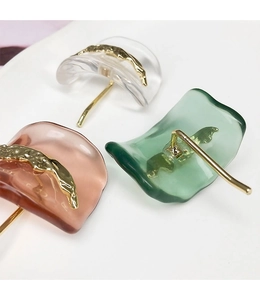 Detail of colorful resin irregular wavy stud earrings with elegant gold-tone metal studs