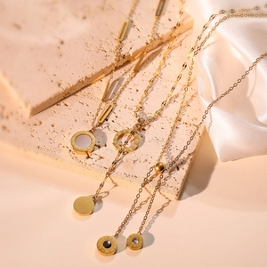 Gold plated stainless steel necklaces with Roman numeral pendants on silk background