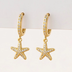 Close-up of gold starfish earrings with micro-pave white zircon stones for women