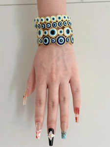 Detailed view of stackable gold-plated bracelets featuring iconic blue Evil Eye motifs