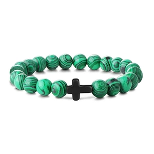 Detailed close-up of a green malachite beaded bracelet with a black cross pendant charm