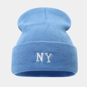 Close-up of white NY embroidery on a light blue knitted beanie winter hat