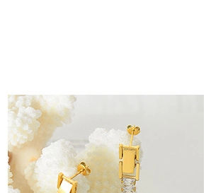 Macro detail of 18k gold heart crystal rings featuring rectangle zircon stones on coral decor
