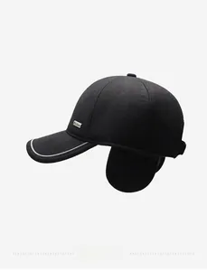 Detail of winter baseball cap featuring folding ear flaps and a metallic fashion logo