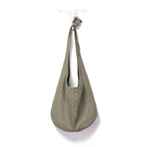 Detail of army green canvas shoulder bag showing the decorative knot on the strap