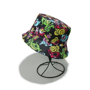Close-up of black bucket hat featuring colorful cartoon monster prints on a wire display