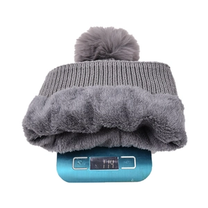 Detail view of winter knitted beanie showing weight on scale and thick fleece lining