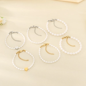 Vintage pearl bracelet set with heart pendants in gold and silver finish on beige background