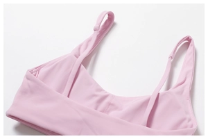 Détail de la brassière de yoga rose clair avec bretelles lisses et coutures soignées